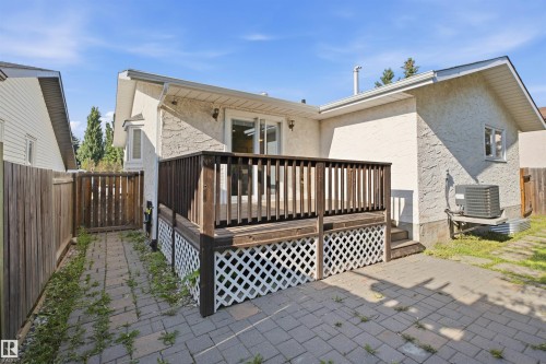 Wood deck with lattice skirting, paver patio, stucco exterior, and bay window - 3515 20 Ave Nw, Edmonton, AB - Outdoor With Deck Patio Veranda With Exterior