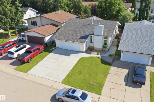 White stucco exterior with an attached garage, a paved driveway, and a front lawn - 3515 20 Ave Nw, Edmonton, AB - Outdoor