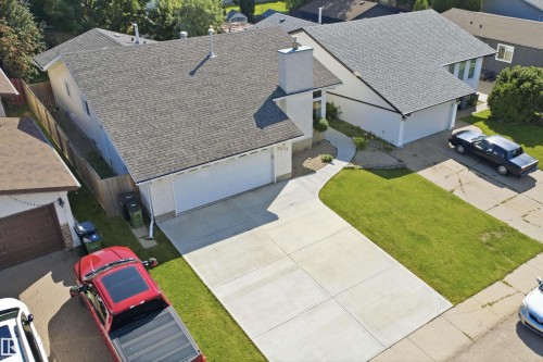 Split-level residence featuring an attached double-car garage, concrete driveway, and a shingle roof - 3515 20 Ave Nw, Edmonton, AB - Outdoor