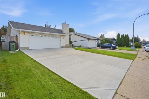 Exterior featuring a two-car garage, concrete driveway, white stucco finish, and a dark shingle roof - 3515 20 Ave Nw, Edmonton, AB - Outdoor