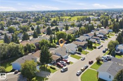 Residential neighborhood with mature trees and a clear sky - 