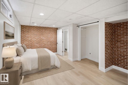 Exposed brick accent walls, light wood-finish flooring, recessed lighting, and a window with blinds - 3515 20 Ave Nw, Edmonton, AB - Indoor Photo Showing Bedroom