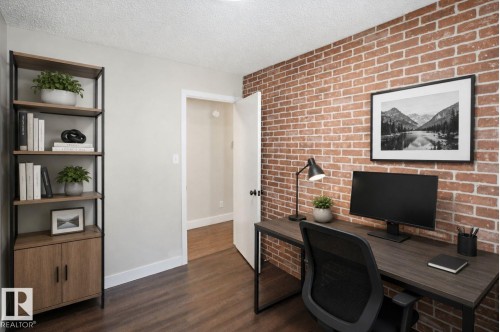 Exposed brick accent wall, wood-finish flooring, recessed lighting, and a built-in shelving unit - 3515 20 Ave Nw, Edmonton, AB - Indoor Photo Showing Office