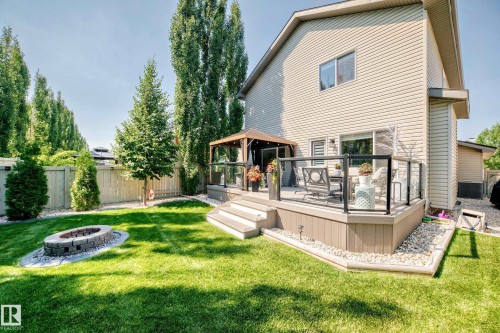 Spacious backyard with a composite deck, glass panel railing, and stone fire pit feature - 823 77 Street Sw, Edmonton, AB - Outdoor With Deck Patio Veranda
