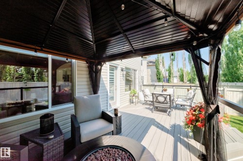 Spacious composite deck with a dark metal gazebo featuring string lighting - 823 77 Street Sw, Edmonton, AB - Outdoor With Deck Patio Veranda With Exterior