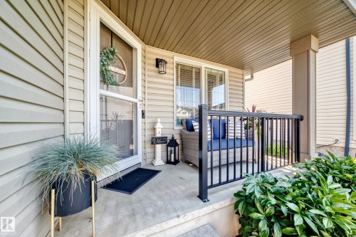 Front porch featuring durable siding, a concrete surface, and a black metal railing - 823 77 Street Sw, Edmonton, AB - Outdoor With Deck Patio Veranda With Exterior