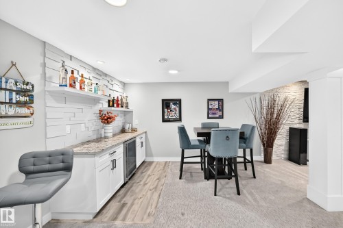 Finished basement entertainment area featuring a wet bar with white cabinetry, a built-in beverage refrigerator, and open shelving - 823 77 Street Sw, Edmonton, AB - Indoor