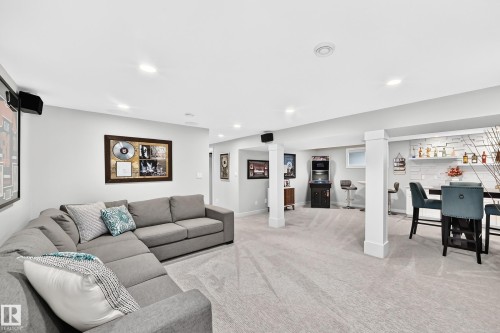 Spacious lower level featuring recessed lighting, light-toned carpeting, and structural support columns - 823 77 Street Sw, Edmonton, AB - Indoor Photo Showing Living Room