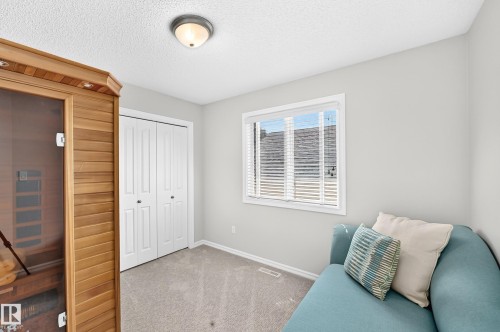 Carpeted room featuring a built-in wood-finish sauna, white bi-fold closet doors, a single window with blinds, and recessed lighting - 823 77 Street Sw, Edmonton, AB - Indoor