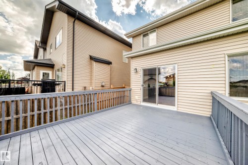 Spacious wood-finish deck with slatted railings, directly accessible via sliding glass doors - 4212 Charles Close Sw, Edmonton, AB - Outdoor With Exterior