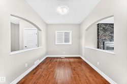 Warm wood-finish flooring, light neutral wall paint, and white trim - 