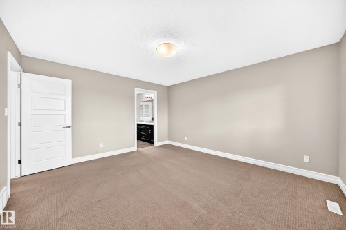 Spacious interior featuring neutral wall tones and a textured ceiling - 4212 Charles Close Sw, Edmonton, AB - Indoor Photo Showing Other Room