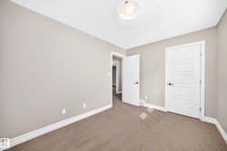 Neutral-toned walls, textured ceiling, flush mount ceiling light, and panel doors with dark hardware - 