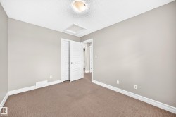 Neutral-toned wall paint, white trim, textured ceiling, and brown carpet flooring - 