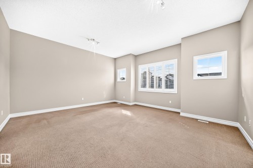Neutral-toned wall paint, recessed lighting, white window frames, and carpeted flooring - 4212 Charles Close Sw, Edmonton, AB - Indoor Photo Showing Other Room