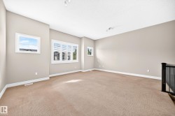Warm neutral wall tones, textured carpeting, white window casings, and white window shutters - 