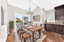 Vaulted ceiling, wood-finish flooring, sliding glass door, built-in cabinetry, and a contemporary chandelier - 4212 Charles Close Sw, Edmonton, AB  - Indoor Photo Showing Dining Room 