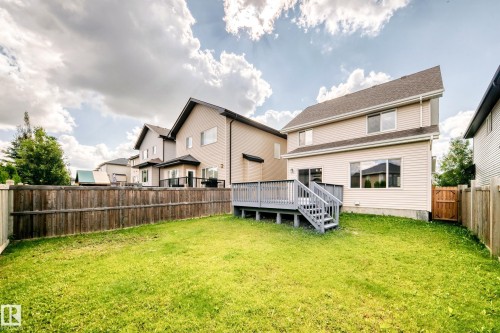 Expansive rear yard featuring green space, a full-height wood fence, and a multi-level deck with steps and railing - 4212 Charles Close Sw, Edmonton, AB - Outdoor