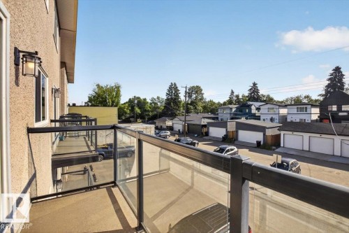 Private balcony with glass railing, concrete flooring, and exterior wall lighting - #205 11429 124 St Nw, Edmonton, AB - Outdoor