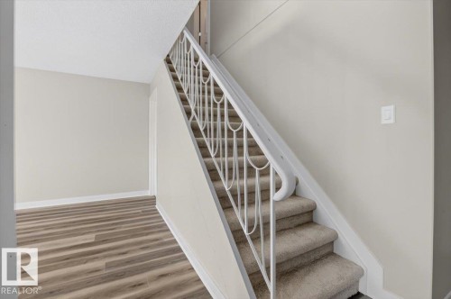 Staircase with carpeted steps and an ornate metal railing - #205 11429 124 St Nw, Edmonton, AB - Indoor Photo Showing Other Room