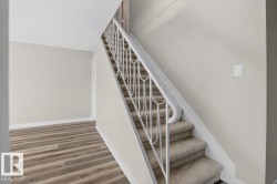 Staircase with carpeted steps and an ornate metal railing - 