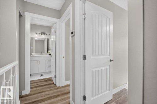 Wood-finish flooring with white trim - #205 11429 124 St Nw, Edmonton, AB - Indoor Photo Showing Other Room