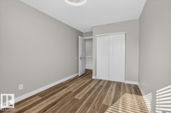 Wood-finish flooring, light gray wall tones, white trim, and a white sliding closet door - 