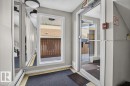 Entryway featuring a full-light glass door, a large fixed window, and mirrored wall panels - #205 11429 124 St Nw, Edmonton, AB  - Indoor Photo Showing Other Room 