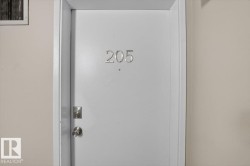 White entry door with a circular knob, deadbolt, and silver numerical address - 