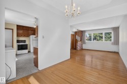 Hardwood flooring, chandelier lighting, and a large window with natural light - 