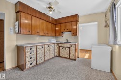U-shaped kitchen with wood-finish upper cabinetry, patterned lower cabinetry, and light-toned countertops - 