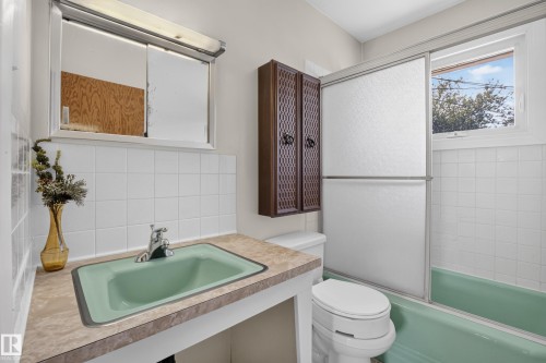 Bathroom with a built-in vanity, integrated green sink, and a mirrored medicine cabinet - 16009 93A Avenue Nw, Edmonton, AB - Indoor Photo Showing Bathroom