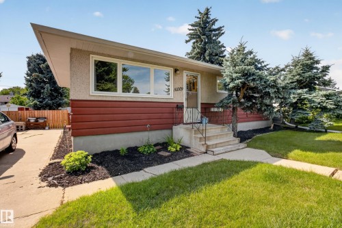 Exterior featuring a covered entryway, front walkway, concrete steps with metal railing, and mature landscaping - 16009 93A Avenue Nw, Edmonton, AB - Outdoor