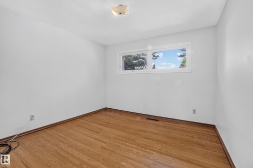 Hardwood flooring, painted walls, and a ceiling-mounted light fixture - 16009 93A Avenue Nw, Edmonton, AB - Indoor Photo Showing Other Room