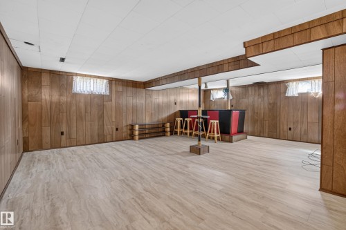Finished lower level with wood-finish paneling, drop ceiling, and light-toned flooring - 16009 93A Avenue Nw, Edmonton, AB - Indoor