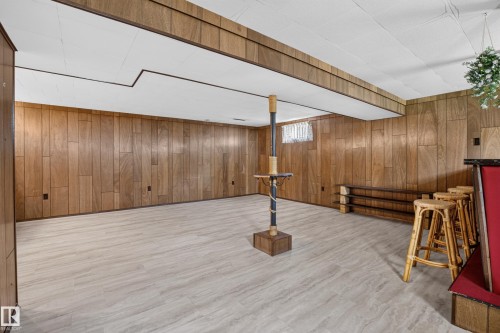 Light wood-finish flooring, wood paneling, and a built-in bar - 16009 93A Avenue Nw, Edmonton, AB - Indoor