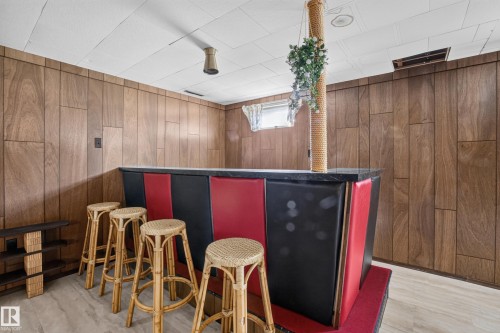 Wood-paneled wall, built-in bar, and suspended ceiling - 16009 93A Avenue Nw, Edmonton, AB - Indoor Photo Showing Other Room