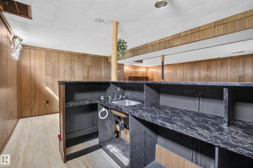 Built-in bar with a stainless steel sink and a dark, patterned countertop - 16009 93A Avenue Nw, Edmonton, AB -  With Exterior