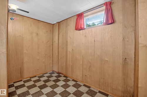 Wood-paneled room featuring a window and checkered flooring - 16009 93A Avenue Nw, Edmonton, AB - Indoor Photo Showing Other Room