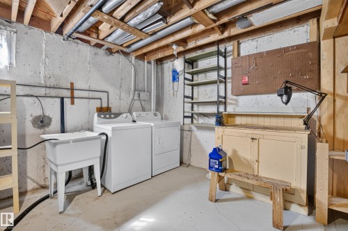 Utility sink, exposed ceiling beams, washer, dryer, pegboard organization - 16009 93A Avenue Nw, Edmonton, AB - Indoor Photo Showing Laundry Room