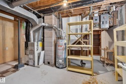 Exposed ceiling joists, concrete block wall construction, forced-air furnace system, water heater, and electrical service panels - 