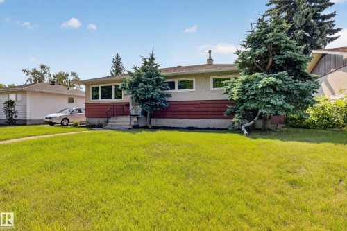 Front exterior with a light stucco finish, red horizontal siding, and multiple front-facing windows - 16009 93A Avenue Nw, Edmonton, AB - Outdoor