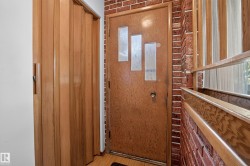 Wood-finish accordion door, brick wall accent, wood-finish entry door with three frosted glass panels, wood-finish window frame - 