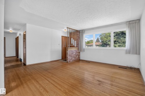 Wood-finish flooring throughout, white wall finishes, and a textured ceiling - 16009 93A Avenue Nw, Edmonton, AB - Indoor
