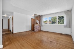 Wood-finish flooring throughout, white wall finishes, and a textured ceiling - 