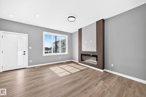 Wood-finish flooring, recessed lighting, and a modern ceiling fixture - 426 Crystal Creek Link, Leduc, AB - Indoor Photo Showing Other Room