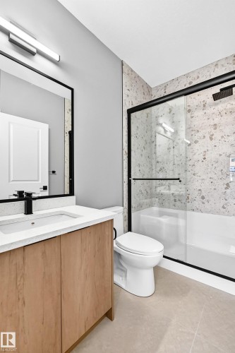 Light wood-finish vanity with a white countertop and rectangular sink - 426 Crystal Creek Link, Leduc, AB - Indoor Photo Showing Bathroom
