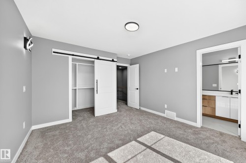 Gray carpeting, white walls, and a modern ceiling light fixture - 426 Crystal Creek Link, Leduc, AB - Indoor Photo Showing Other Room