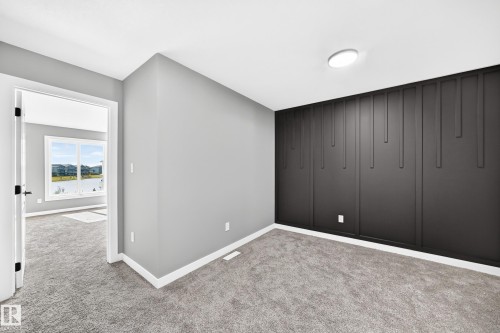 Textured accent wall, neutral carpeting, recessed lighting, and a white trim finish - 426 Crystal Creek Link, Leduc, AB - Indoor Photo Showing Other Room
