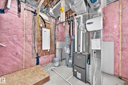 Insulated walls with visible framing, modern electrical panel, furnace system, water heater, and overhead ductwork - 426 Crystal Creek Link, Leduc, AB - Indoor Photo Showing Basement